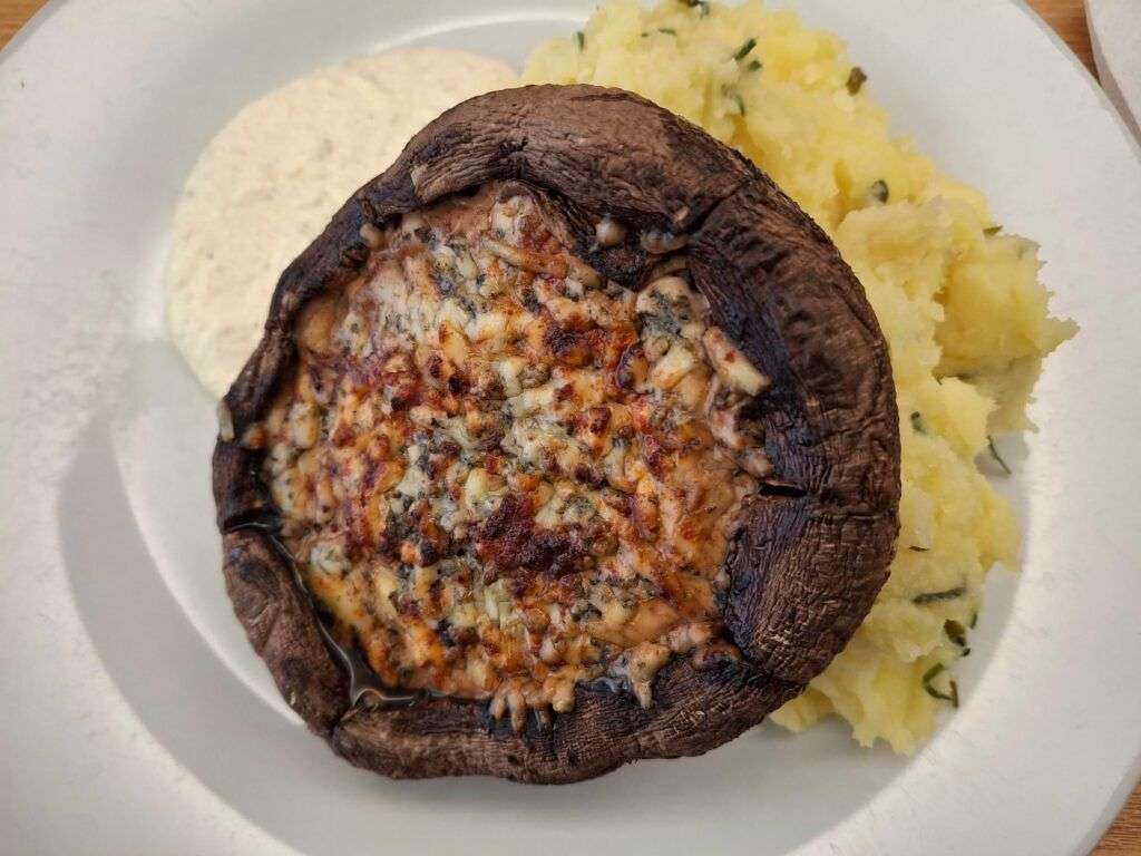 Portobello plněné modrým sýrem typu niva - žampiony jsou podávané s bramborovou kaší a tatarkou